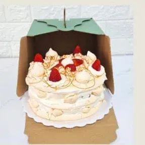 Torta de merengue de 10 porciones decorada con frutillas, en su caja de cartón